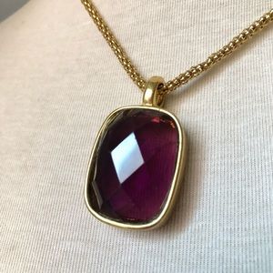 Amethyst colored rectangular faceted glass gem in a gold tone bezel with chain